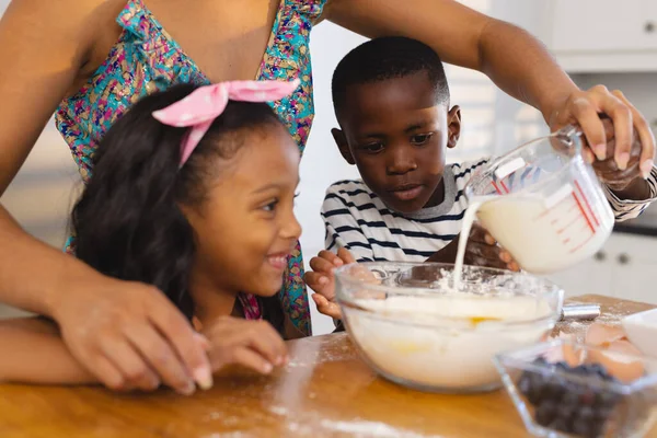 Midsection Multiracial Mother Pouring Milk Bowl While Standing Children Kitchen — Stock Photo, Image