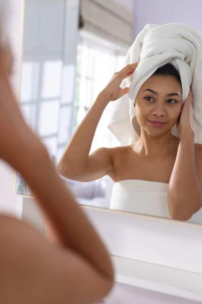 在浴室的镜子里 一个快乐的女人在头上调整毛巾的垂直方向微笑着 有着复制的空间 自我照顾 休闲和生活方式概念 — 图库照片