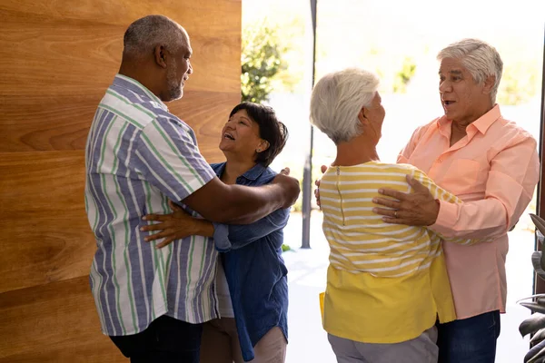 Dwurasowi Seniorzy Obejmujący Wesołych Przyjaciół Stojących Drzwi Domu Opieki Szczęśliwy — Zdjęcie stockowe