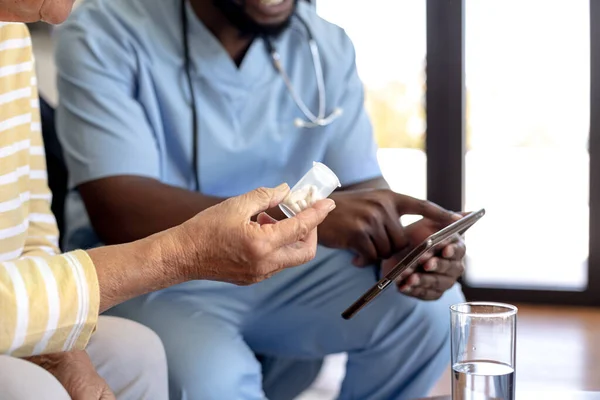 Mężczyzna Pracownik Służby Zdrowia Tabletką Cyfrową Omawia Starszą Kobietą Rasy — Zdjęcie stockowe