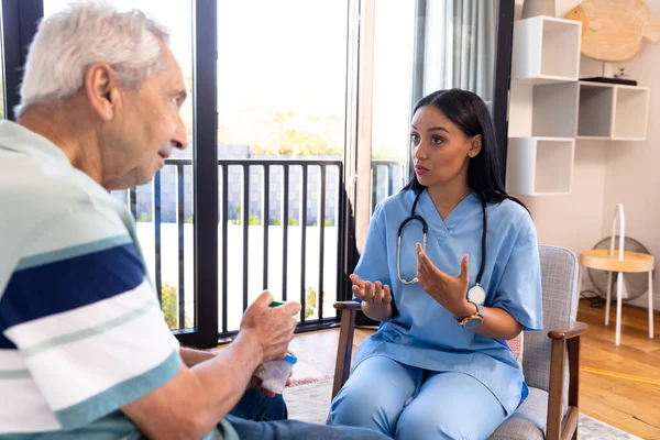 Fisioterapeuta Biracial Mujer Hablando Con Hombre Mayor Caucásico Mientras Está —  Fotos de Stock
