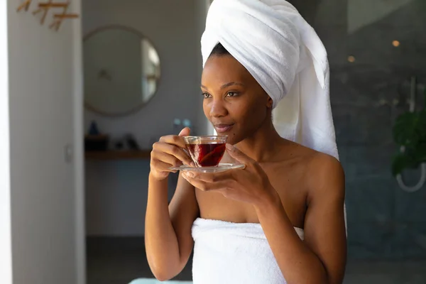 Αφροαμερικανή Νεαρή Γυναίκα Τυλιγμένη Πετσέτες Πίνει Υγιεινά Στο Σπίτι Αντιγράφει — Φωτογραφία Αρχείου