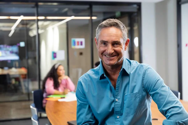 オフィスの役員室で成熟した白人ビジネスマンの笑顔の肖像画 変化のない創造的なビジネス職場前向きな感情 — ストック写真