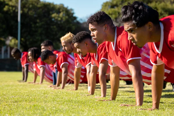 Male Multiracial Players Wearing Red Uniforms Row Doing Push Ups — Stock Photo, Image