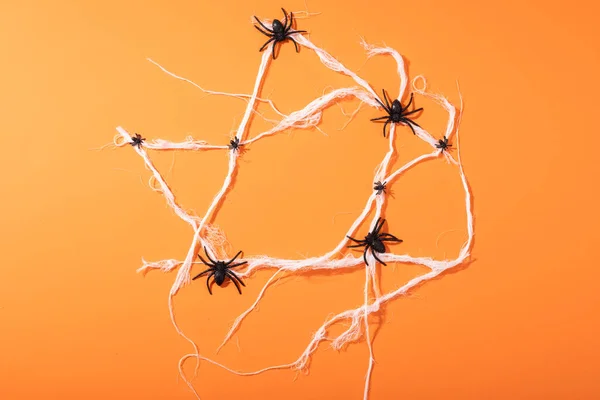 Mehrere Spinnenspielzeuge Bilden Ein Spinnennetz Mit Kopierraum Vor Orangefarbenem Hintergrund — Stockfoto