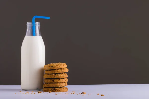 灰色の背景にクッキーのスタックでわらとミルクボトル コピースペース 変更されていない 食べ物 飲み物 スタジオで撮影された健康的な食品コンセプト — ストック写真