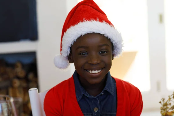 サンタの帽子をかぶったアフリカ系アメリカ人の少女の肖像画 カメラを見て笑顔 家族の時間クリスマスのお祝い — ストック写真