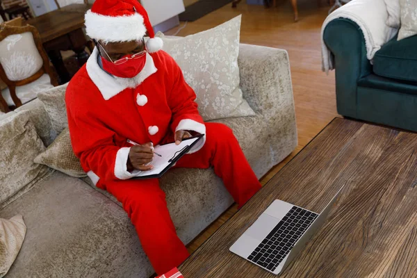 Senior Afroameričan Kostýmu Santa Clause Červené Masky Píše Podložku Používá — Stock fotografie