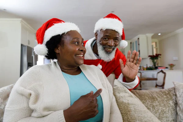 高级非洲裔美国人夫妇笑着 头戴桑塔帽 一个男人看着相机 优质家庭时间圣诞庆祝活动 — 图库照片