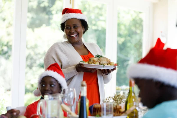 Ältere Afrikanisch Amerikanische Frau Serviert Abendessen Lächelt Und Trägt Weihnachtsmütze — Stockfoto