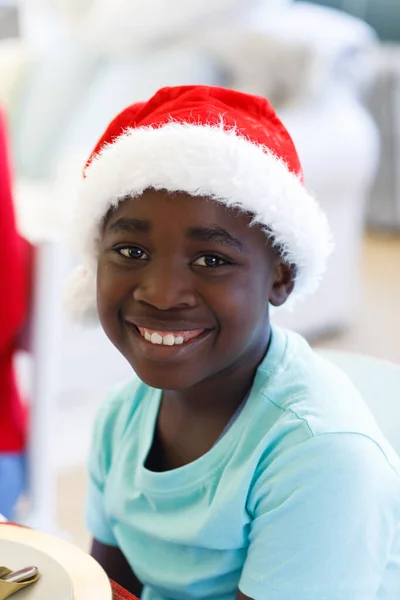 サンタの帽子をかぶったアフリカ系アメリカ人の少年の肖像画 カメラを見て笑顔 家族の時間クリスマスのお祝い — ストック写真