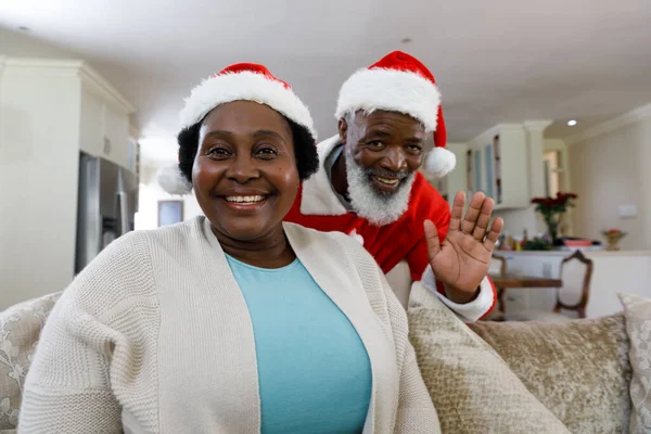 高级非洲裔美国人夫妇面带微笑 头戴桑塔帽 看着相机的画像 优质家庭时间圣诞庆祝活动 — 图库照片
