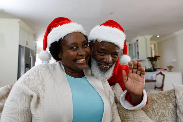 シニアアフリカ系アメリカ人のカップルの笑顔とサンタの帽子を着て カメラを見ての肖像画 家族の時間クリスマスのお祝い — ストック写真