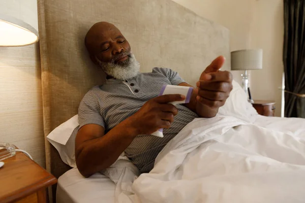 Den Äldre Afrikanske Amerikanske Mannen Spenderar Tid Hemma Liggandes Sängen — Stockfoto