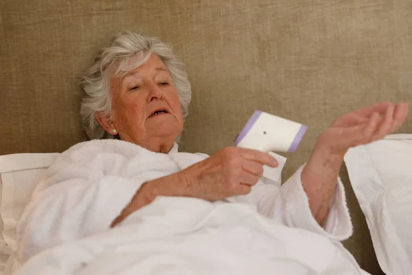 Starsza Biała Kobieta Spędzająca Czas Domu Leżąca Łóżku Mierząca Temperaturę — Zdjęcie stockowe