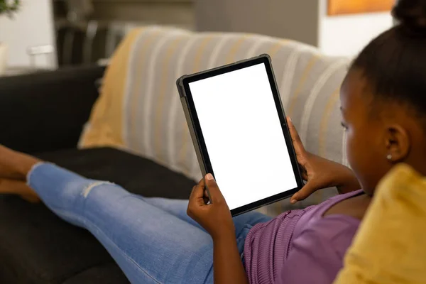 Ευτυχισμένη Αφροαμερικανή Κοπέλα Χαλαρώνει Στον Καναπέ Στο Σπίτι Χρησιμοποιώντας Tablet — Φωτογραφία Αρχείου
