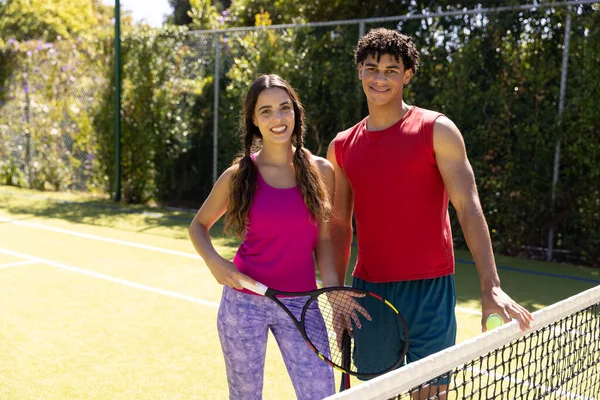 Portrait Happy Diverse Couple Tennis Rackets Net Sunny Outdoor Tennis — Stock Photo, Image