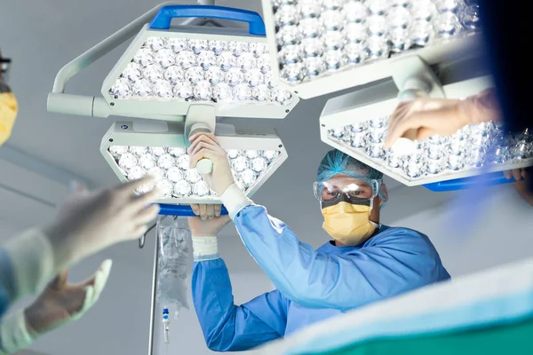 Cirujano Masculino Caucásico Ajustando Luz Para Colegas Quirófano Cirugía Hospital —  Fotos de Stock