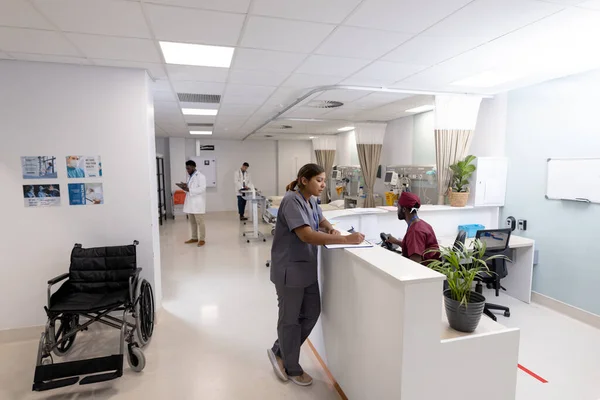 亚洲女医生在医院病房接待处的剪贴板上书写 复印空间 医疗和保健服务 — 图库照片