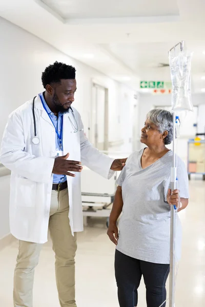 Αφροαμερικάνος Γιατρός Μιλάει Διάφορες Ηλικιωμένες Γυναίκες Ασθενείς Στάγδην Στο Διάδρομο — Φωτογραφία Αρχείου