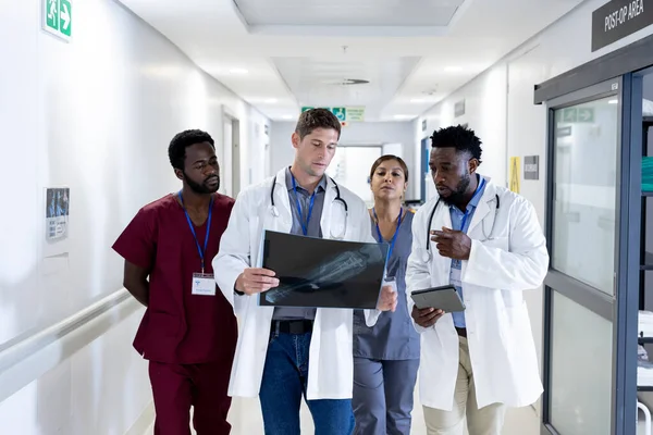 病院の廊下でX線歩行について議論する医師の多様なグループ 医療サービス — ストック写真
