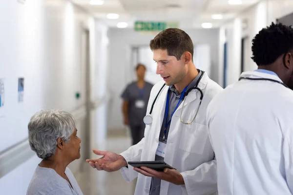 Biały Lekarz Tabletkami Rozmawiający Pacjentką Ruchliwym Korytarzu Usługi Szpitalne Medyczne — Zdjęcie stockowe