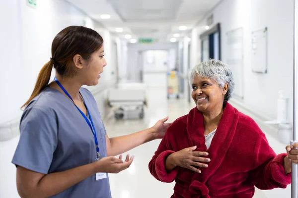 在医院走廊里 亚洲女医生和各种各样的老年女性微笑交谈 医疗和保健服务 — 图库照片