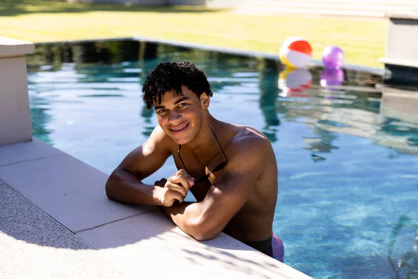 笑顔の肖像画水着姿の生身の男がサングラスを持ってプールに立っている 自由時間 リラクゼーションと休暇 — ストック写真