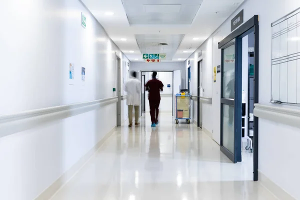 Zamazany Ruch Różnych Lekarzy Spacerujących Ruchliwym Korytarzu Szpitalnym Przestrzeń Kopiowania — Zdjęcie stockowe