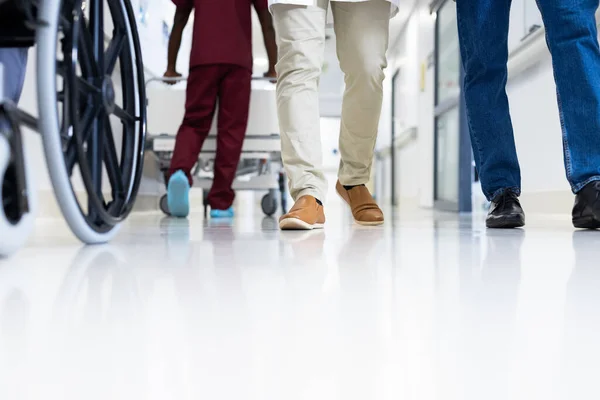 Yoğun Hastane Koridorunda Düşük Seviyeli Erkek Doktorlar Tekerlekli Sandalyeler Kopyalama — Stok fotoğraf
