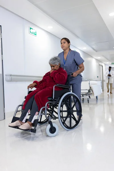 アジアの女性医師は 病院の廊下で車椅子で多様な高齢女性患者を押しています 医療サービス — ストック写真