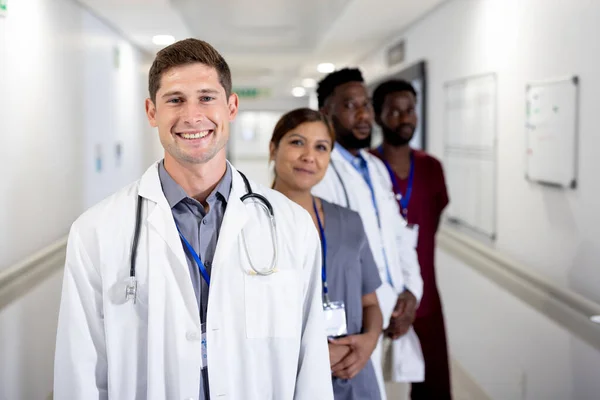 Unaltered Portrait Smiling Caucasian Male Doctor Diverse Colleagues Hospital Corridor — Stock Photo, Image