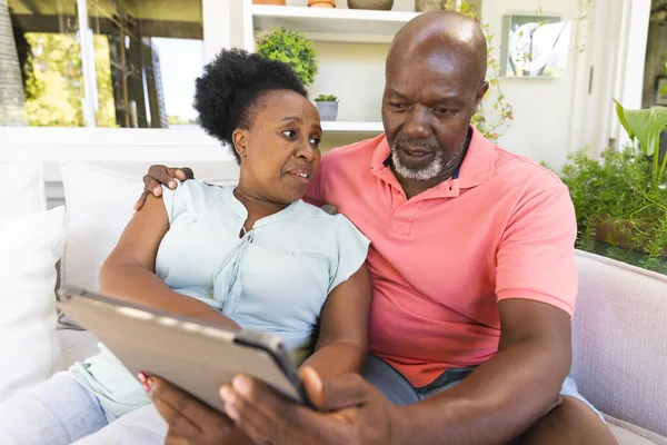 Casal Americano Africano Sênior Sofá Usando Tablet Conversando Sala Estar — Fotografia de Stock