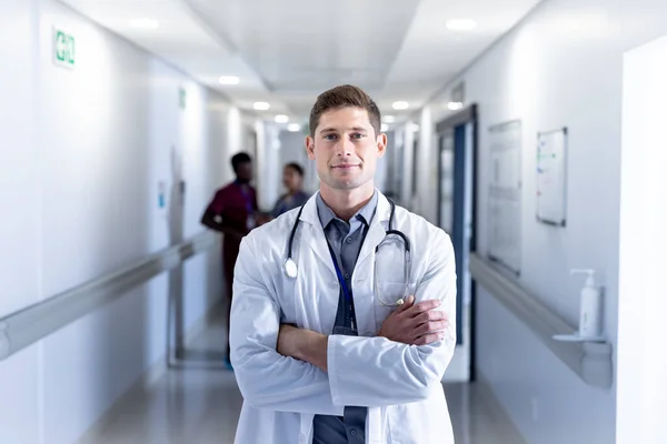 Unaltered Portrait Caucasian Male Doctor Arms Crossed Smiling Hospital Corridor — Stock Photo, Image