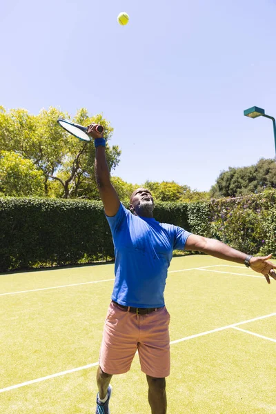Счастливый Афроамериканец Играет Теннис Растягиваясь Ударить Мячу Солнечной Травяной Площадке — стоковое фото