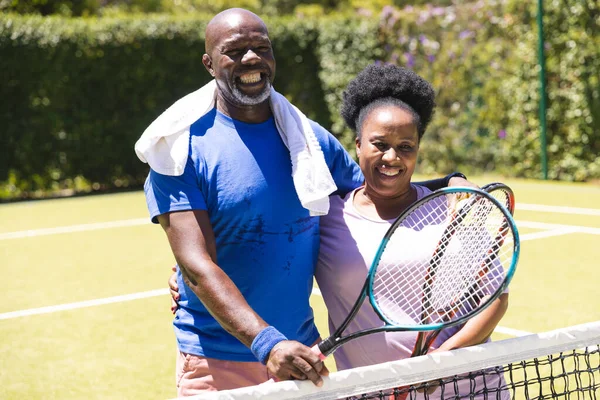 Feliz Pareja Afroamericana Senior Con Raquetas Tenis Abrazándose Soleada Cancha — Foto de Stock