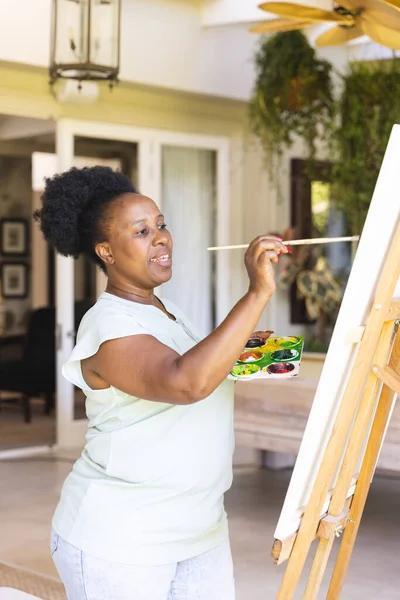 Συγκεντρωμένη Χαρούμενη Ηλικιωμένη Αφροαμερικανή Που Κρατάει Ζωγραφιά Καμβά Στο Σπίτι — Φωτογραφία Αρχείου