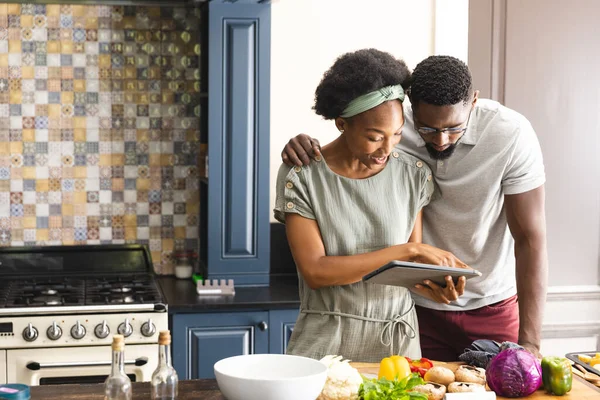アフリカ系アメリカ人のカップルが台所でタブレットを使用して一緒に食事を準備しました 健康的なライフスタイル レシピ コミュニケーション 一緒に 食品や国内生活 変更なし — ストック写真