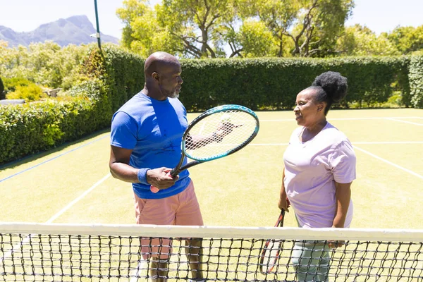 Feliz Pareja Afroamericana Senior Con Raquetas Tenis Hablando Soleada Cancha — Foto de Stock