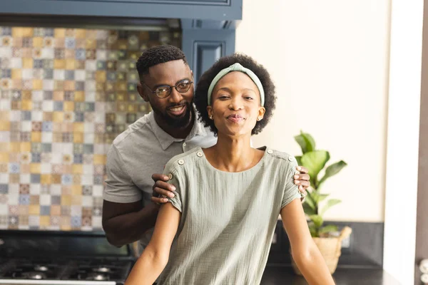 幸せなアフリカ系アメリカ人夫婦がキッチンで抱き合って笑顔の肖像画 ライフスタイル 団結と国内生活 変わらない — ストック写真