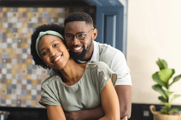 幸せなアフリカ系アメリカ人夫婦がキッチンで抱き合って笑顔の肖像画 ライフスタイル 団結と国内生活 変わらない — ストック写真