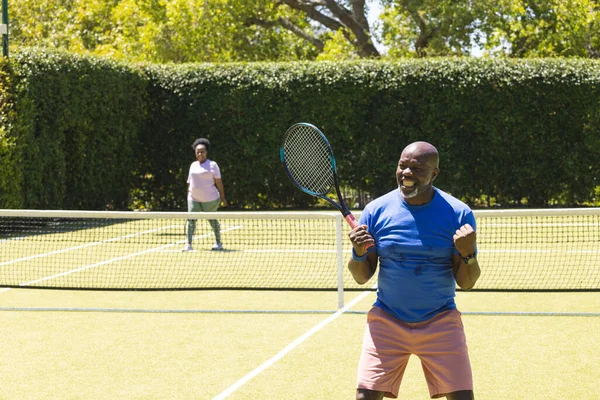 Счастливая Старшая Африканская Пара Теннисными Ракетками Мужчина Празднует Солнечном Теннисном — стоковое фото