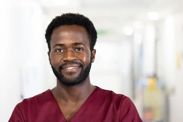 病院の廊下に立って にこにこ笑顔でアフリカ系アメリカ人男性医師の変わらない肖像画 フレンドリーで親しみやすく 仕事の満足感 医療サービス — ストック写真