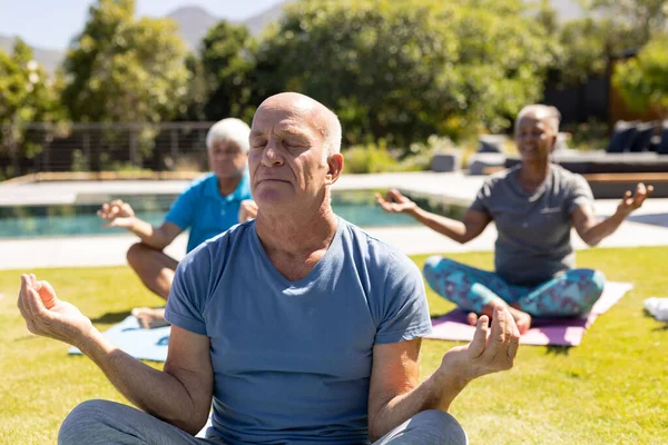 快乐多样的老朋友坐在阳光灿烂的花园里练习瑜伽冥想 老年生活方式 积极退休 莲花地位 健康和幸福 — 图库照片