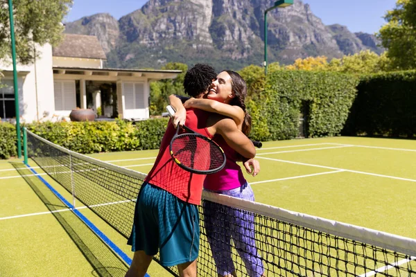 Biracial Feliz Joven Pareja Con Raquetas Tenis Abrazando Mientras Que —  Fotos de Stock