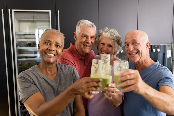 Portret Szczęśliwych Zróżnicowanych Starszych Przyjaciół Wznoszących Toast Zdrowymi Koktajlami Kuchni — Zdjęcie stockowe