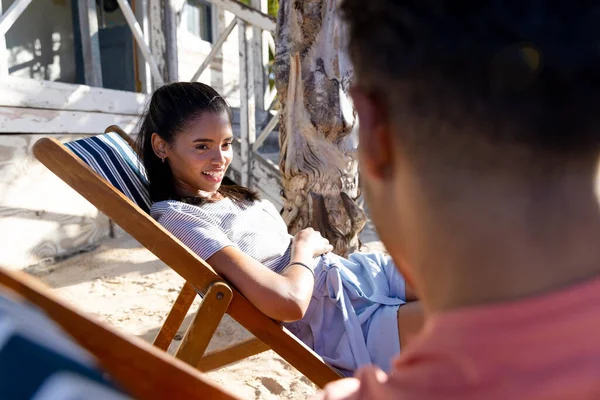 Усміхнена Біла Молода Жінка Розмовляє Хлопцем Сидячи Стільцях Пляжі Неперевершена — стокове фото