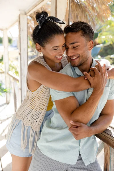 コテージバルコニーに立っている間 白人の若いカップルは笑顔とロマンス 変更されていない 一緒に 観光リゾート ライフスタイルと楽しみの概念 — ストック写真