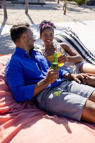 Cheerful Caucasian Young Couple Toasting Beer Bottles While Relaxing Loungers — Stock Photo, Image