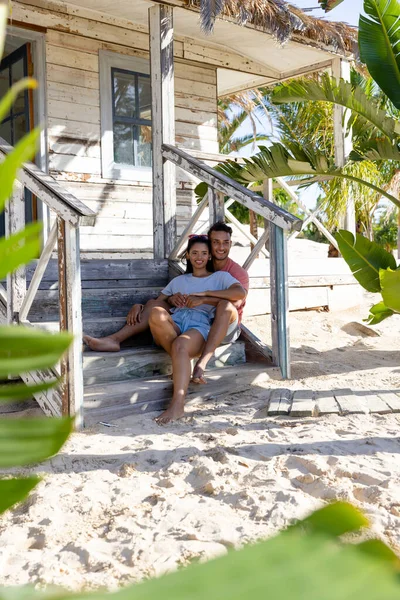 コテージの外の木製の階段に座っている間 白人のロマンチックな若いカップルが離れて見ている 変更されていない 一緒に 観光リゾート ライフスタイル ビーチ 楽しみと夏のコンセプト — ストック写真